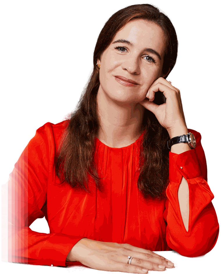 Sabine Karunanithy in an orange blouse, resting her chin on her hand and smiling